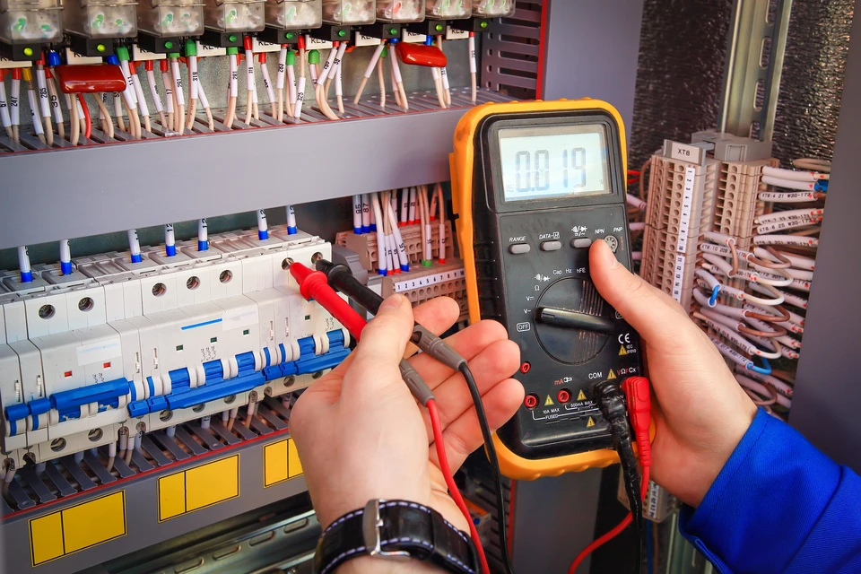 Homme d'affaires en chemise rayée manipulant une maquette architecturale multi-niveaux représentant un immeuble résidentiel moderne avec espaces intérieurs détaillés