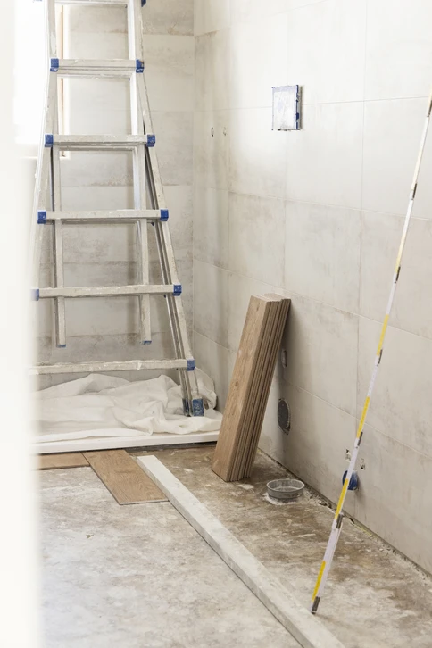 Travaux de rénovation intérieure, application d'enduit ou mortier sur mur avec outil de lissage à dents