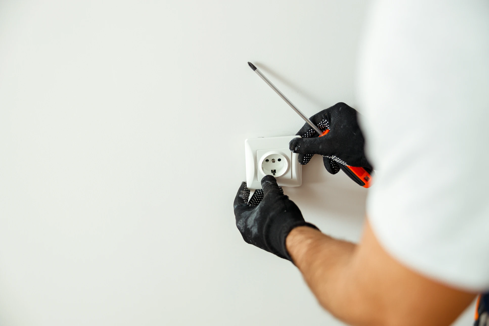 Chantier de rénovation intérieur avec ouvrier appliquant de l'enduit sur mur en briques apparentes