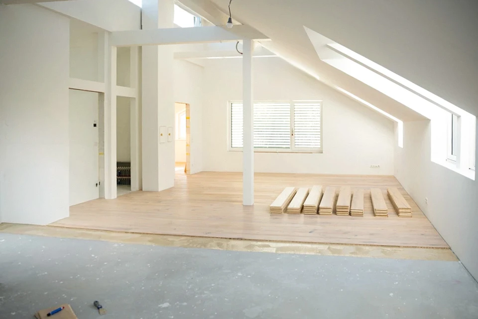 homme d'âge moyen aux cheveux gris collés, portant du parquet dans mon appartement loft, dernier étage