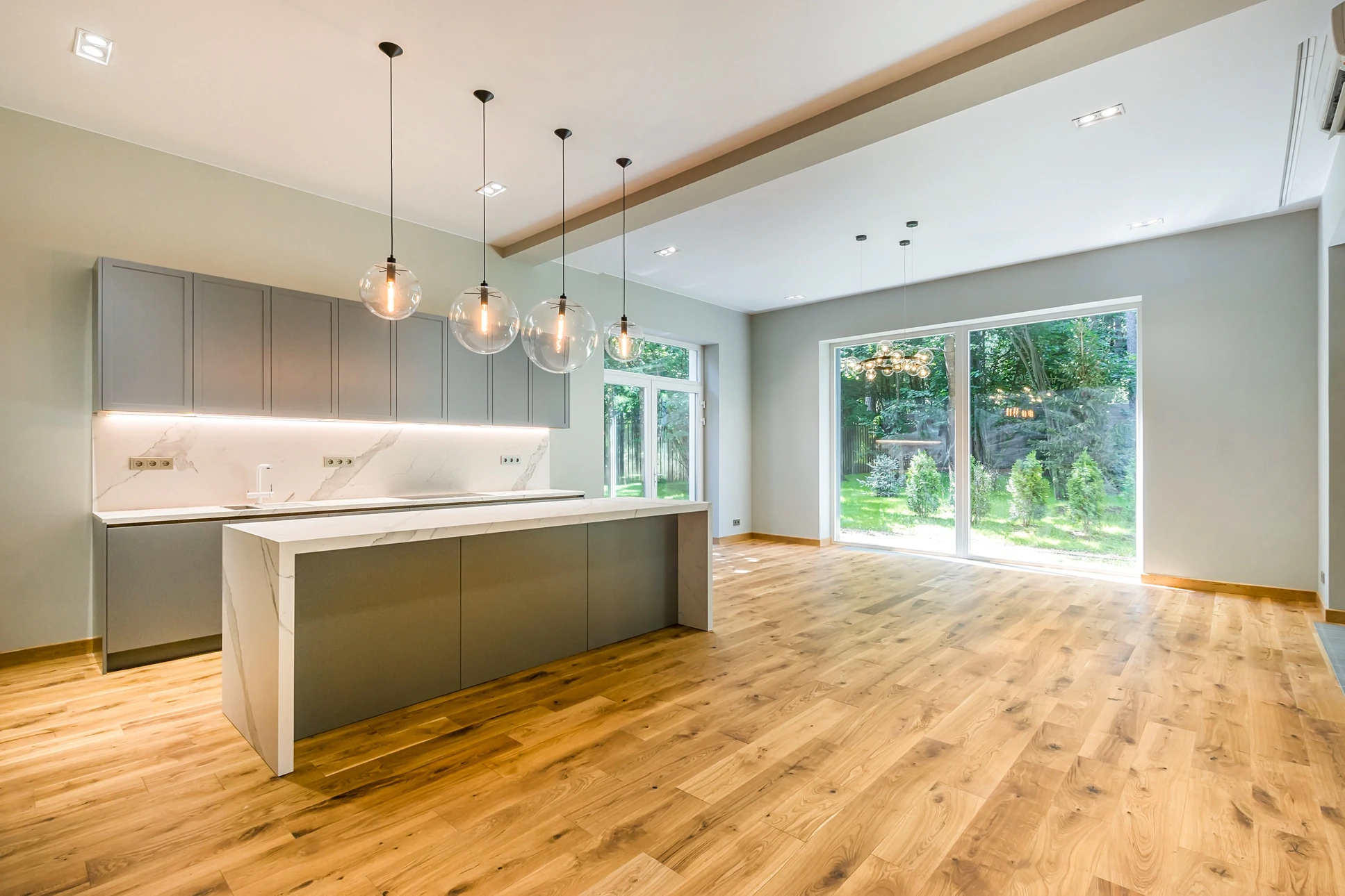 Photographie en intérieur résidentiel moderne montrant un beau sol fraîchement rénové avec revêtement de qualité (parquet clair, carrelage ou sol moderne selon le style). Vue d'ensemble d'une pièce lumineuse avec le sol parfaitement lissé et fini, sans aucune personne visible, mettant en valeur la beauté et la finition professionnelle du travail de pose réalisé.