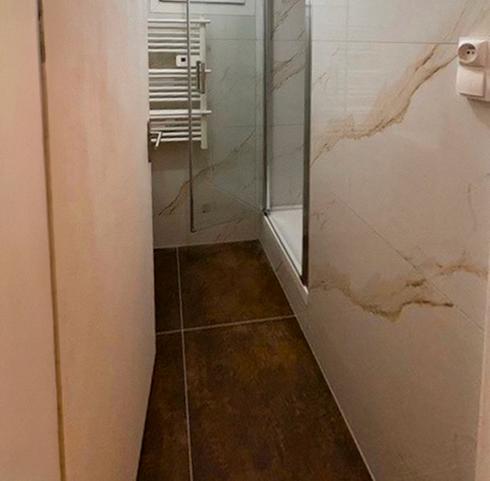 Intérieur en cours de rénovation avec contraste saisissant entre zone de travaux et espace rénové